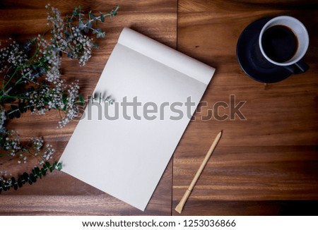 Flat lay of blank white notebook with cup coffee on wooden table. Copy space. ready for adding text or mockup. 