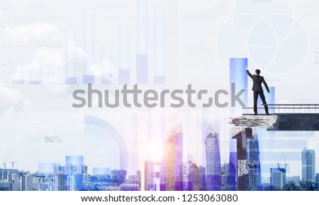 Businessman in suit drawing graphs on modern statistical media interface while standing on broken bridge with cityscape and sunlight on background. 3D rendering.