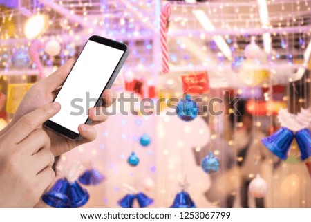 businessman holding blank screen for text on smartphone, mobile, cell phone with blurry Christmas decoration background.