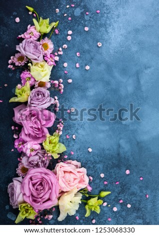 Beautiful  flowers on vintage blue background. Festive floral concept with clean space for text. Top view.