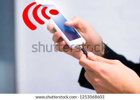 hand with mobile phone and wifi signal charging