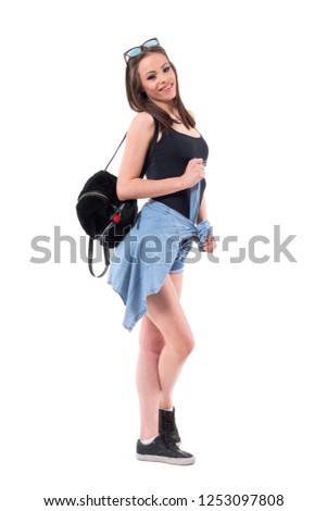 Side view of millennial modern style woman carrying plush bag and sunglasses on head. Full body isolated on white background. 