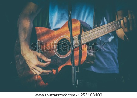 Cheerful guitarist. Cheerful handsome young man playing guitar