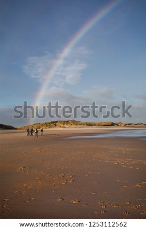 Beautiful rainbow on the beach at Druridge Bay in Northumberland, North East England on a cold and windy December morning