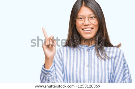 Young asian woman over isolated background pointing finger up with successful idea. Exited and happy. Number one.