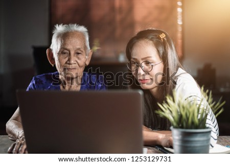Asian Grandmother and granddaughter are looking to social media, Thai family