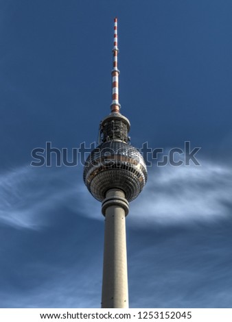 Almost abstract picture of a radio waves emitting antenna against dark blue sky with some light cirrus clouds. Berlin TV tower (Fernsehturm) on Alexanderplatz.