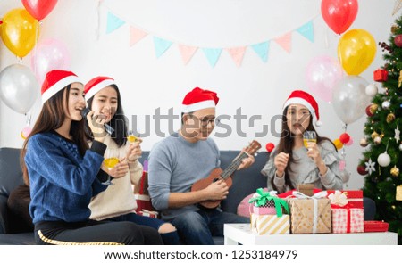 Asian happy friends with Santa hat celebrating in Christmas party