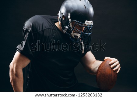 Sport concept. American football sportsman player in black sports outfit on black background with copy space. Sport concept.