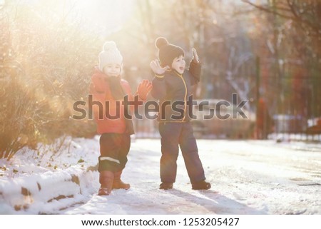 children in winter park play with snow
