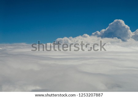 a field of clouds spreading where ever you look.  Picture was taken through a airplane window
