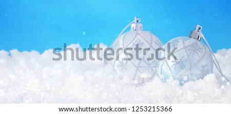 Image of christmas festive tree white ball decoration in front of blue background. Glitter overlay