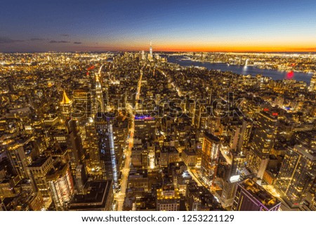 Illuminated Skyline of Manhattan, New York in the evening twilight after sunset. United States of America. Aerial View