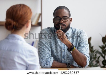 Diverse business people sitting in office, black ceo interviewing female for company position feel doubts that candidate meets requirements. Bad first impression and unsuccessful job interview concept Royalty-Free Stock Photo #1253230837