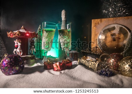 Two glasses of champagne with Christmas decoration. Traditional winter holiday alcohol drink in snow with creative New Year artwork. Copy space. Selective focus