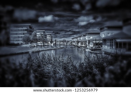 Modern architecture in a new district.  Happy people living in a nice and relaxing neighbourhood. Black and white picture showing also sky and clouds which gives a different atmosphere.
