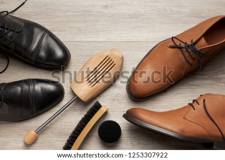 Top view of leather men's shoes and boots with a shoe tree and a brush, room for text Royalty-Free Stock Photo #1253307922