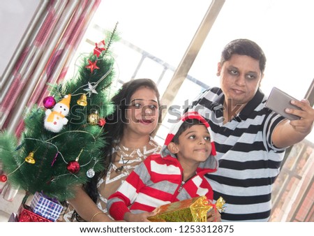 Happy Indian family taking selfie during Christmas celebration at home
