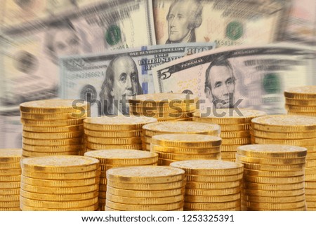 Golden money stacks in front of a pile of Dollar bank notes. Euro money and finance concept.