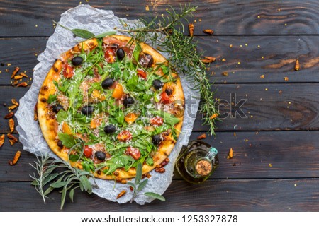 Fresh homemade domestic pizza with homegrown bio tomatoes on old wooden rustic board