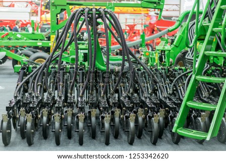 Corn harvester head with several silver blades. Agricultural machinery for soil cultivation.