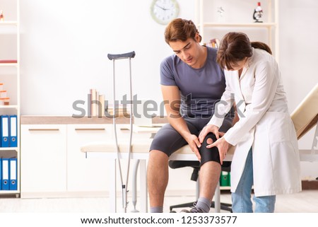 Young male patient visiting female doctor traumatologist  Royalty-Free Stock Photo #1253373577