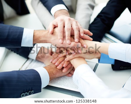 Close-up of business partners making pile of hands at meeting Royalty-Free Stock Photo #125338148