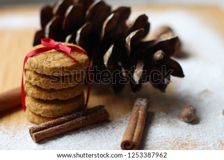 Christmas or New Year background of spices, nuts, cones. Biscuits with red ribbons