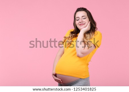 Beautiful pregnant woman on pink background