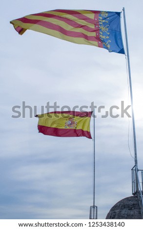 Spanish and Valencias flags waving in the sky