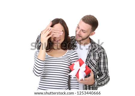 Beautiful young couple with gift box on white background