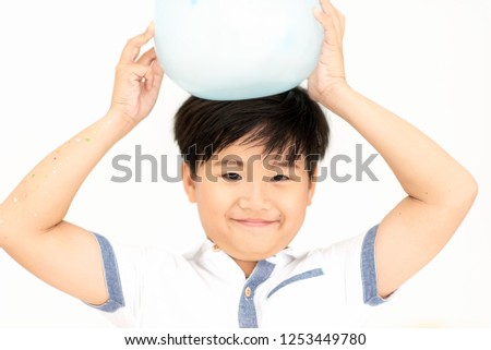 Close up of Happy Asian Boy Smiling and Holding Balloon on Head in Celebrate Event Having Fun in Christmas New Year Party or Birthday on Holiday