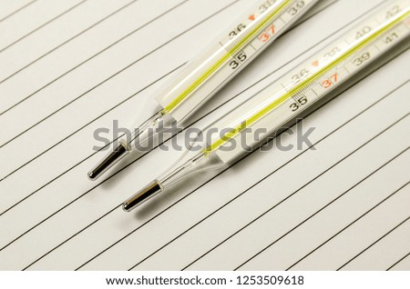 Thermometer for measuring the temperature of the human body, lies on the wooden surface of the table, close-up