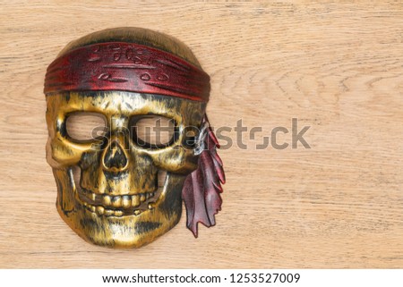 Plastic mask of a pirate in the shape of a skull on an old wooden table