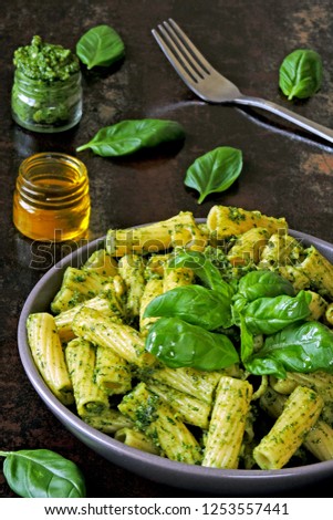 Green pesto pasta with basil. Colorful healthy food in a bowl.