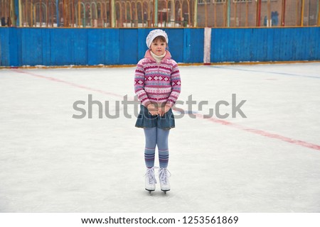 cute little girl ice skating. child winter outdoors on ice rink