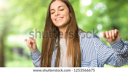 Young girl with striped shirt enjoy dancing while listening to music at a party at outdoors