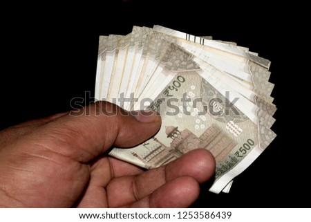 A man holding 500 indian currency notes in hand