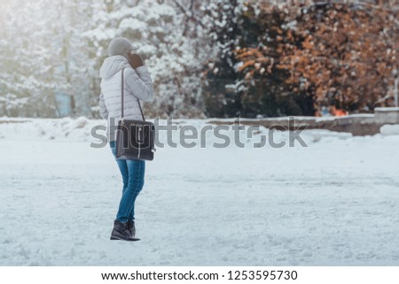 Girl speaks on the phone in the winter park