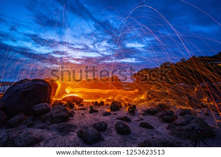 cool burning steel wool fire work photo experiments on the rock at sunrise.

