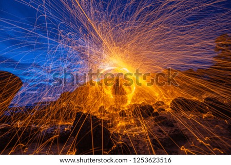 cool burning steel wool fire work photo experiments on the rock at sunrise.
