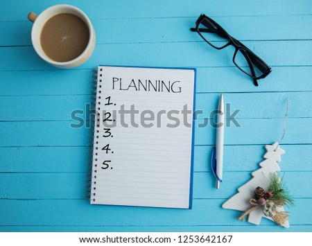 planning text on notepad with coffee and christmas toy on table
