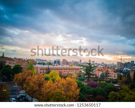 A gorgeous sunset with intense orange and red colors under dark blue clouds in the city of Madrid, Spain, Europe. The photo was taken in the neighborhood of Manoteras, in the north of Madrid.