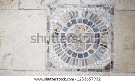 Floor marble mosaic top view. Mandala ornament floor tiles made from small pieces of grey natural stones. Antique Turkish architecture details. Ancient mosaic background. Stone rosette backdrop. 