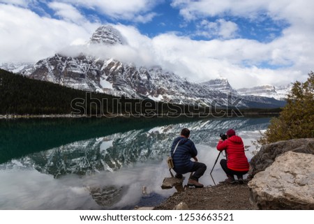 Photographers taking pictures of Beautiful Canadian Rockies Landscape during a cloudy day. Taken in Icefields Pkwy, Banff National Park, Alberta, Canada.