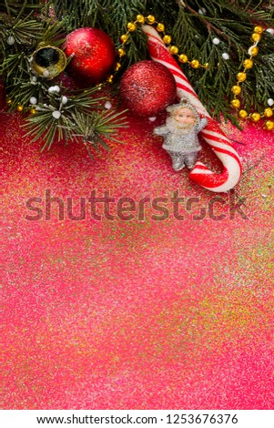Designed Christmas or New Year vertical image with candy cane,christmas ornaments and fresh leaves of pine tree.