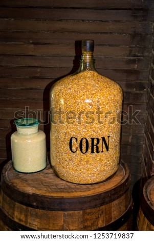 Glass see through jar where you can see many kernels of corn