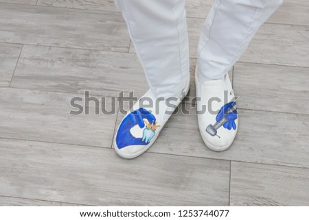 feet of the dentist in shoes with pictures, the subject of dentistry, top view. professional shoes