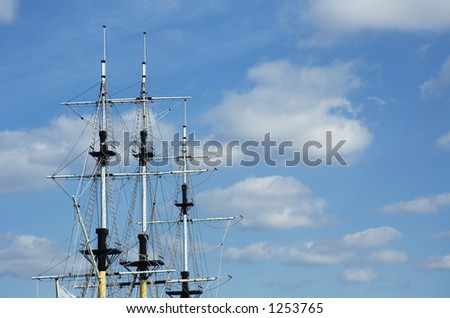masts of frigate over blue sky with space for text
