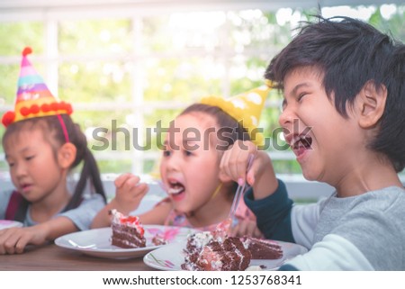 Asian children is happy eating her birthday cake in party
